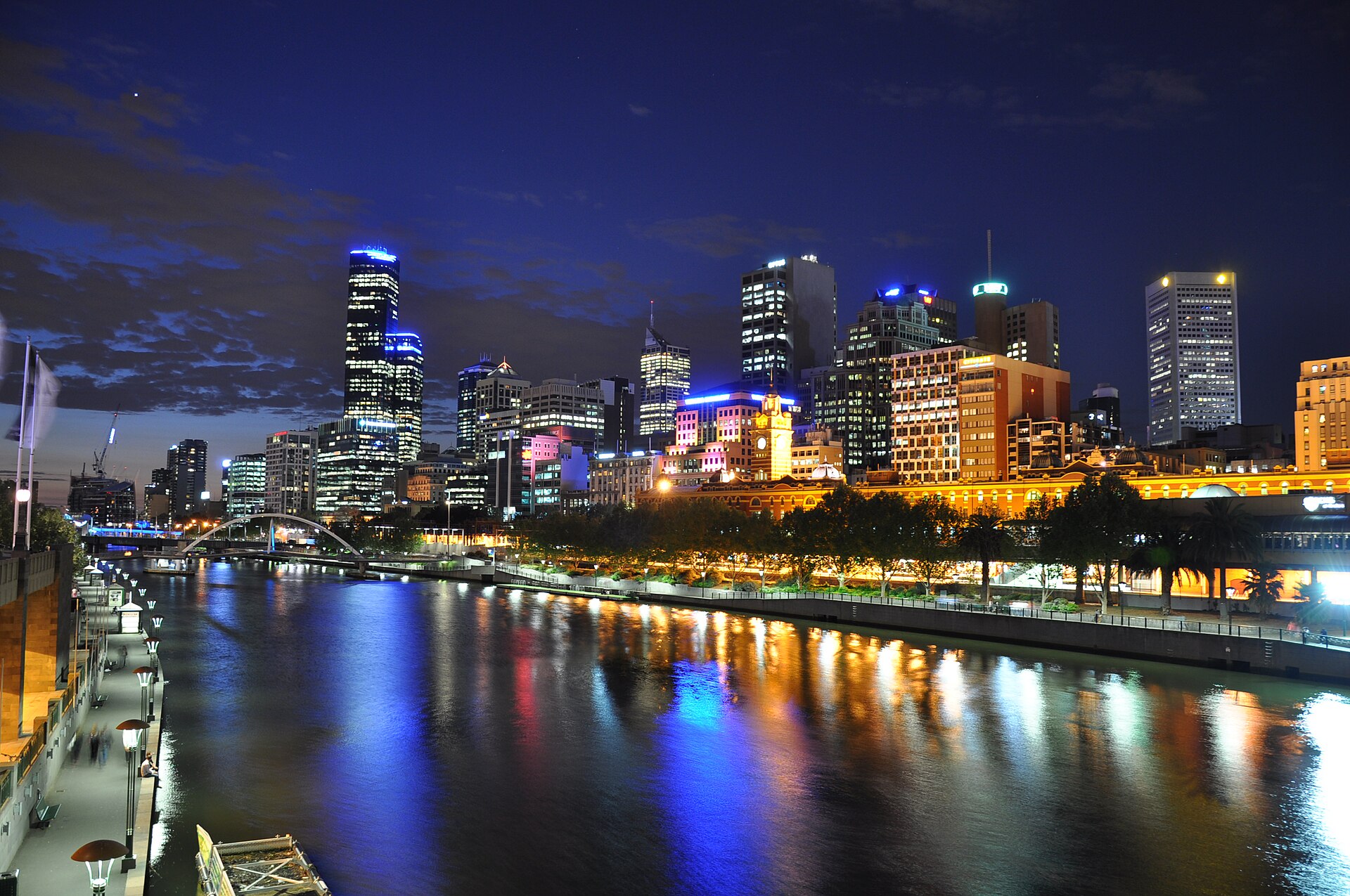 Melbourne’s illuminated skyline reflects on the Yarra River at night, showcasing vibrant city living.