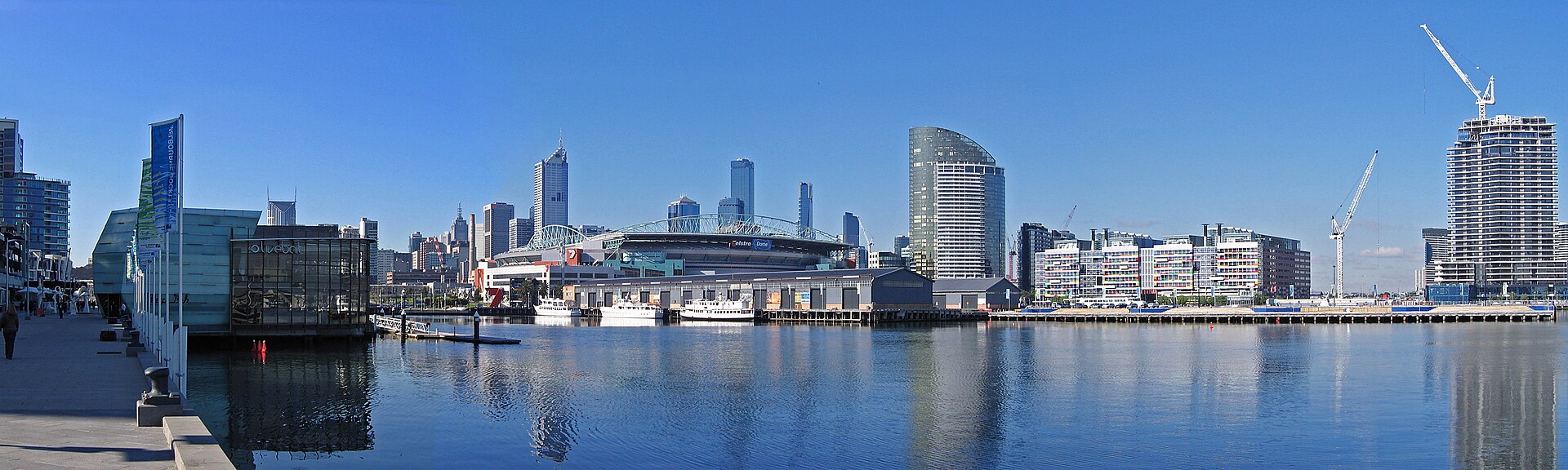 Melbourne’s waterfront skyline and modern buildings are visible from Docklands, reflecting local culture.